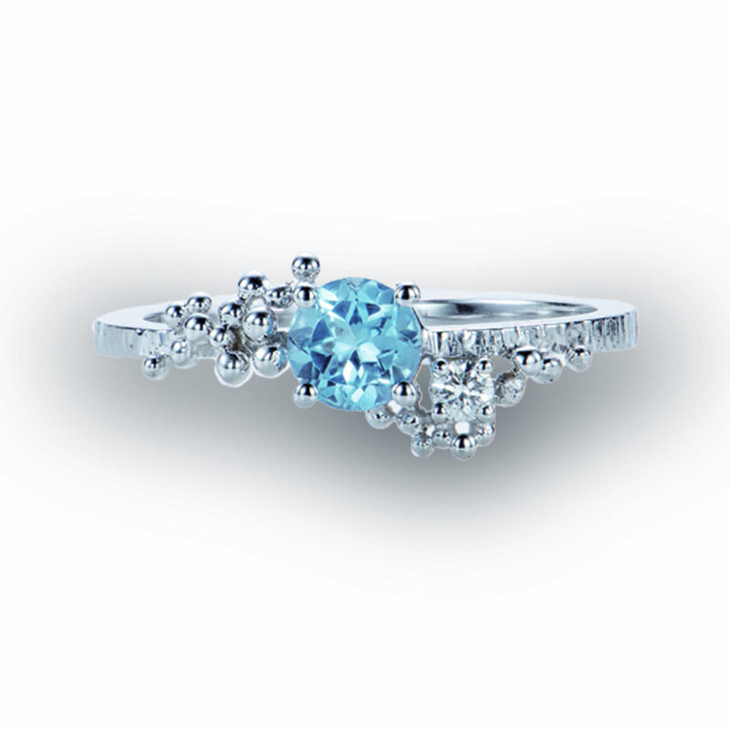 Deze witgouden ring in 18 kt is gezet met een centrale blauwe topaas en versierd met diamant en gouden bolletjes.