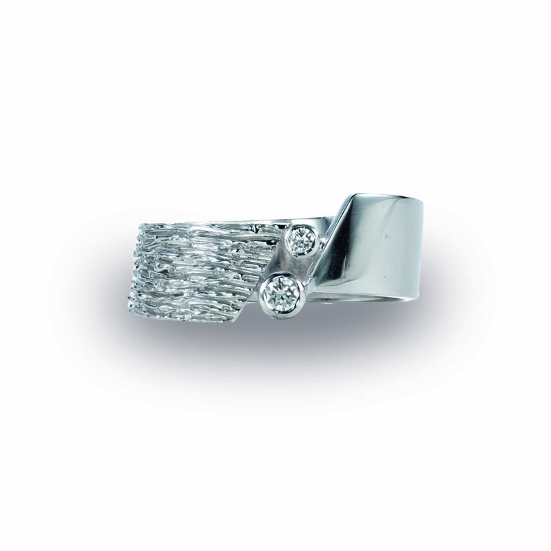 Deze witgouden ring is een combinatie van strakke lijnen en organische structuren en gezet met 2 diamantjes en een creatie van Johan & Jade
