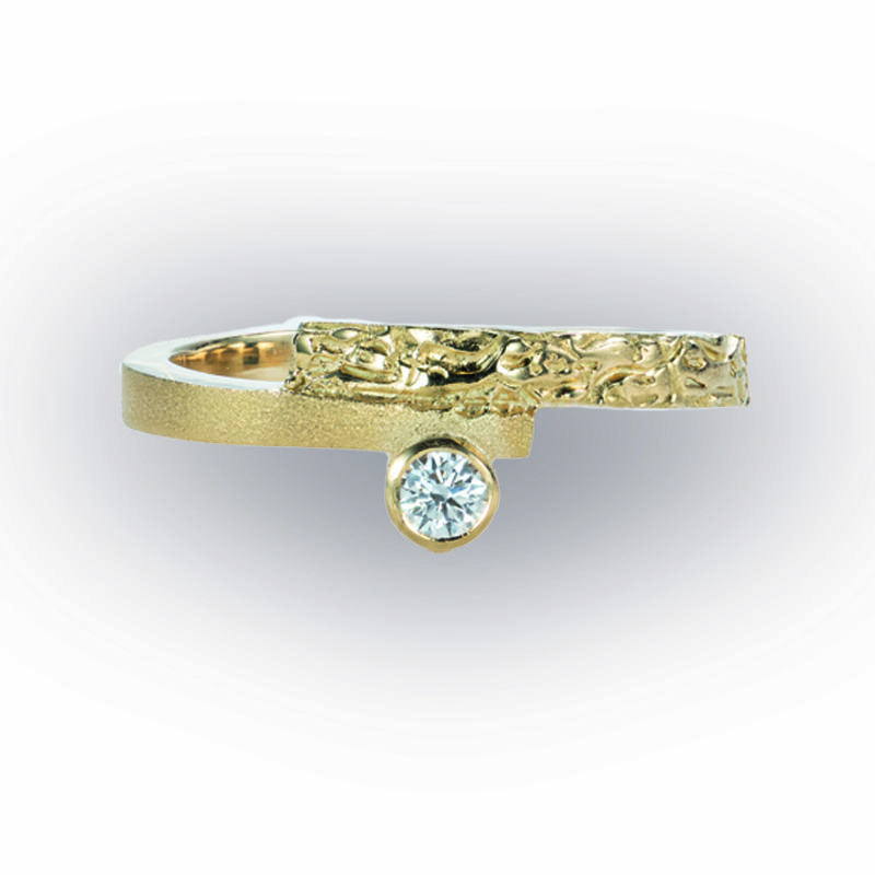 Deze geelgouden ring is een combinatie van organische stijl en een strakke lijn. Natuurlijk met een diamantje als smaakmaker en een ontwerp van Jade.